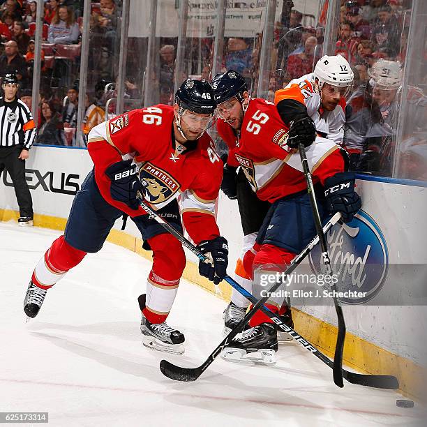 Jakub Kindl and teammate Jason Demers of the Florida Panthers tangle with Michael Raffi of the Philadelphia Flyers at the BB&T Center on November 22,...