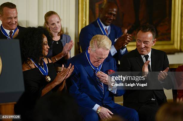 Vin Scully looks at his medal after being presented with the 2016 Presidential Medal Of Freedom by President Obama at the White House on November 22,...