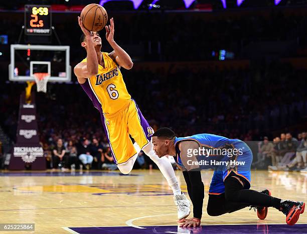 Jordan Clarkson of the Los Angeles Lakers scores on his off balance shot as he is fouled by Russell Westbrook of the Oklahoma City Thunder during a...