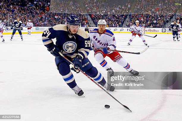 Scott Harrington of the Columbus Blue Jackets skates the puck away from Michael Grabner of the New York Rangers during the game on November 18, 2016...