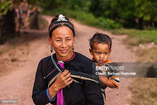 woman from the hill tribe carrying her baby - laotiaanse cultuur stockfoto's en -beelden