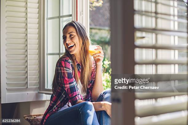 young woman enjoying fresh orange juice - orange juice stock pictures, royalty-free photos & images