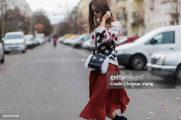 Jennifer Amanda wearing a colorful mohair sweater from Twin Set, a pleated midi skirt from Baum und Pferdgarten in burtn henna, a "so real"...