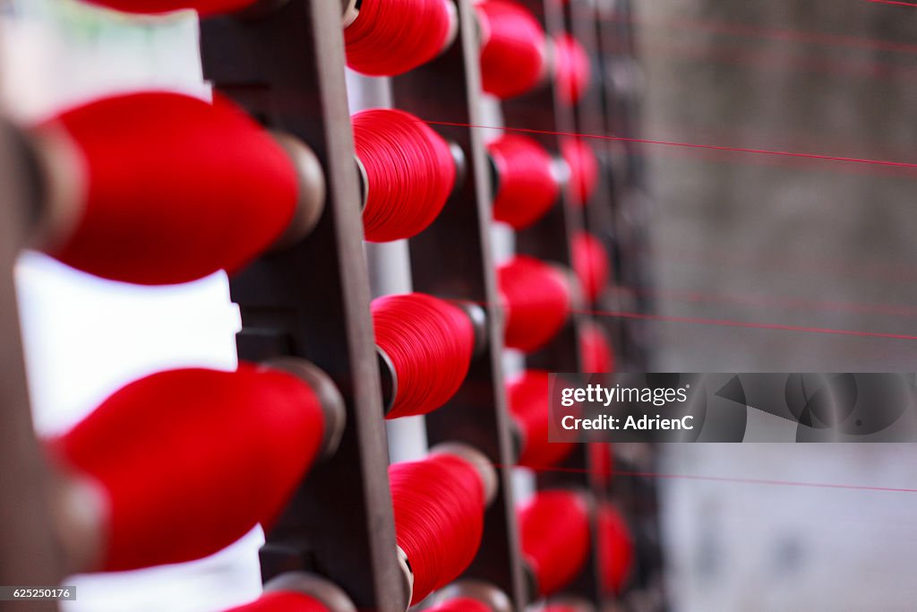 Close up on Bobbins at mechanized loom. Pawtucket