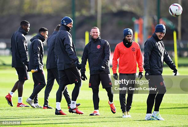 Wayne Rooney and Zlatan Ibrahimovic share a joke during a Manchester United training session on the eve of their UEFA Europa League match against...