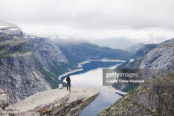 two people on the trolltunga in norway - love on the rocks stock pictures, royalty-free photos & images