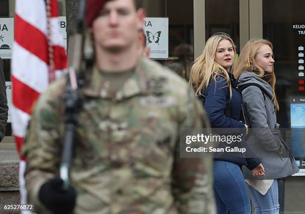 Two young women look on as soldiers of the U.S. 173rd Airborne Brigade stand at attention at the end of a parade during the Iron Sword multinational...