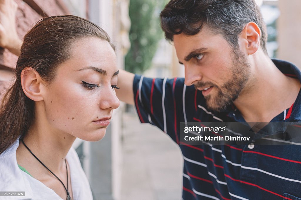 Young man looking at his crying girlfriend