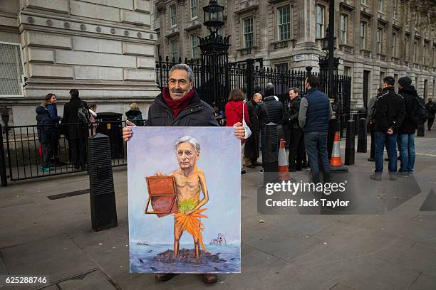 Political artist Kaya Mar displays a painting depicting Chancellor Philip Hammond on November 23, 2016 outside Downing Street in London, England. The...