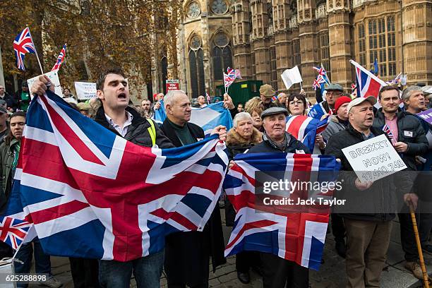 Pro-Brexit demonstrators hold Union Jack flags as they protest outside the Houses of Parliament on November 23, 2016 in London, England. British...