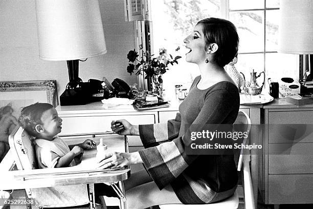 American actress and musician Barbra Streisand makes a face as she feeds her son, Jason, in their home, Beverly Hills, California, 1967.