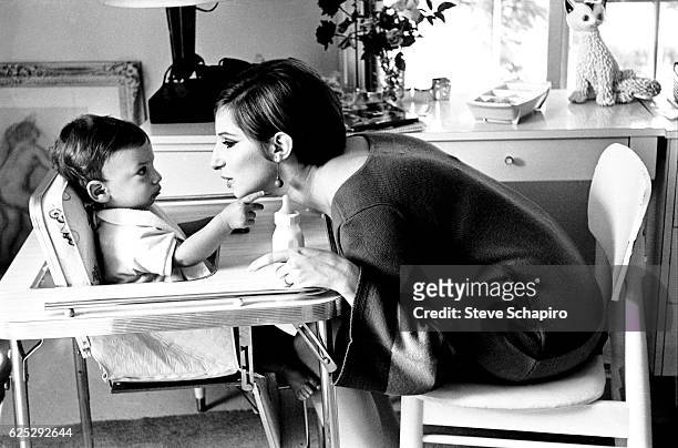 American actress and musician Barbra Streisand makes a face as she feeds her son, Jason, in their home, Beverly Hills, California, 1967.