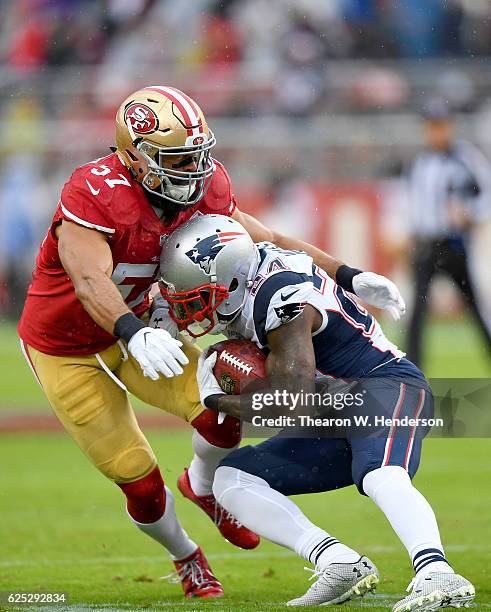 Cyrus Jones of the New England Patriots gets tackled by Michael Wilhoite of the San Francisco 49ers in the first quarter of their NFL football game...