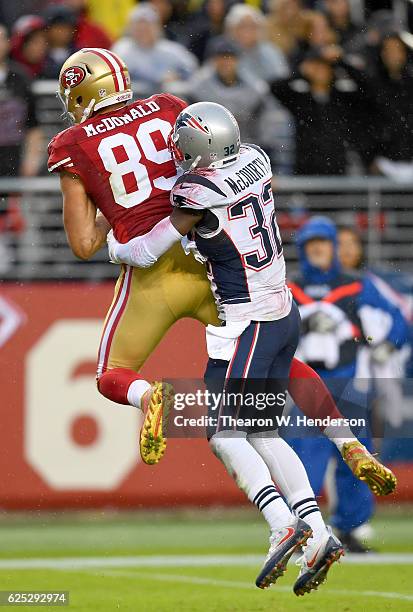 Vance McDonald of the San Francisco 49ers catches an 18-yard touchdown pass over Devin McCourty of the New England Patriots during their NFL game at...
