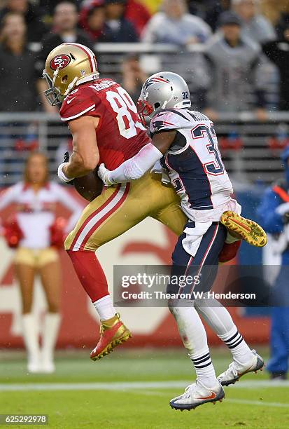 Vance McDonald of the San Francisco 49ers catches an 18-yard touchdown pass over Devin McCourty of the New England Patriots during their NFL game at...