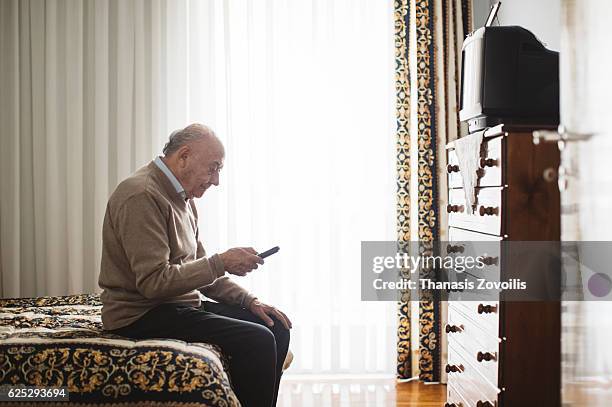 senior man watching television - つまらない仕事 ストックフォトと画像