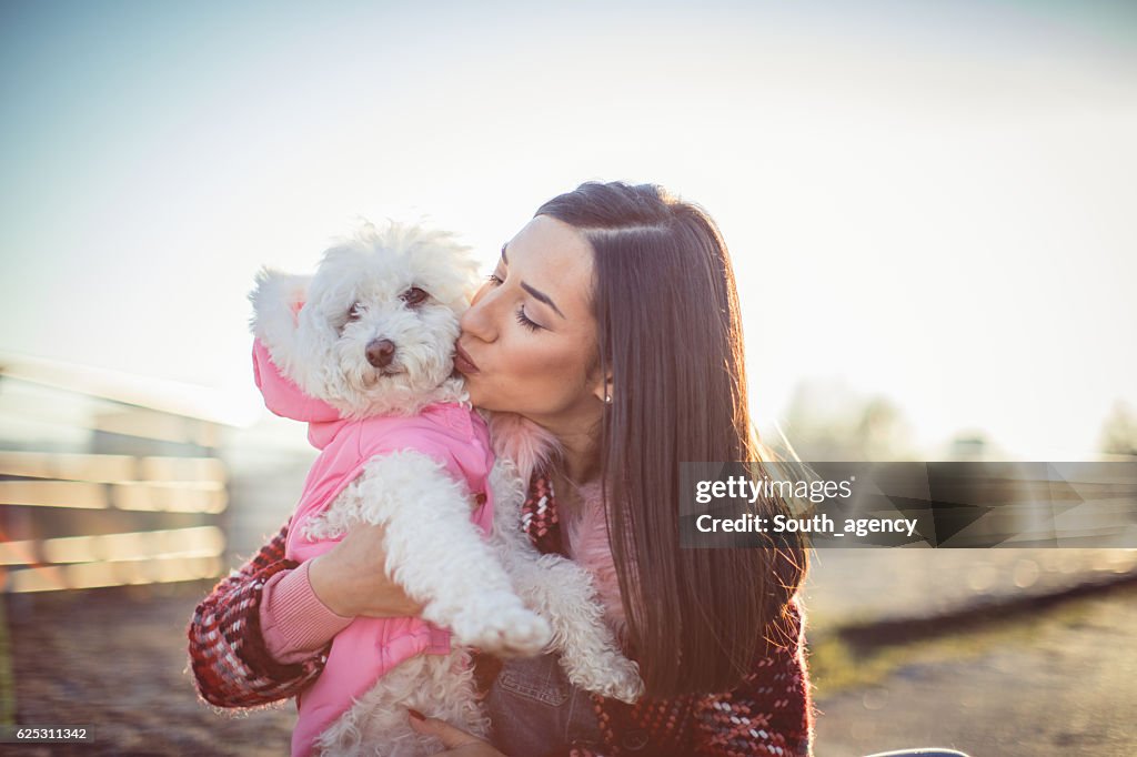 Girl kissing her dog poodle