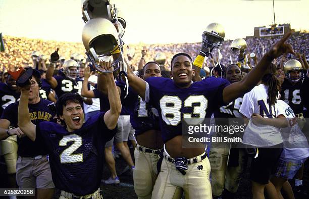 Notre Dame Reggie Ho , Andre Brown , teammates, and fans victorious on field after winning game vs Miami at Notre Dame Stadium. South Bend, IN...