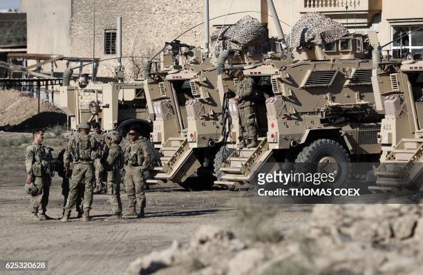 Soldiers are seen next to their armoured vehicles near an Iraqi army base on the outskirts of Mosul, on November 23, 2016. Forces battling the...