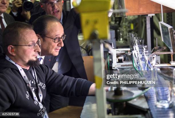 Worker shows French President Francois Hollande how glasses are made during a visit at the headquarters of the French glass-marker ARC, on November...