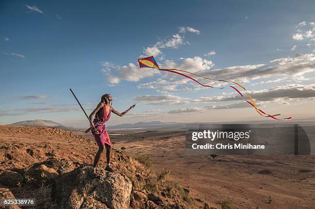 maasia warrior flying kite and having fun with scenic view - nativo da áfrica - fotografias e filmes do acervo