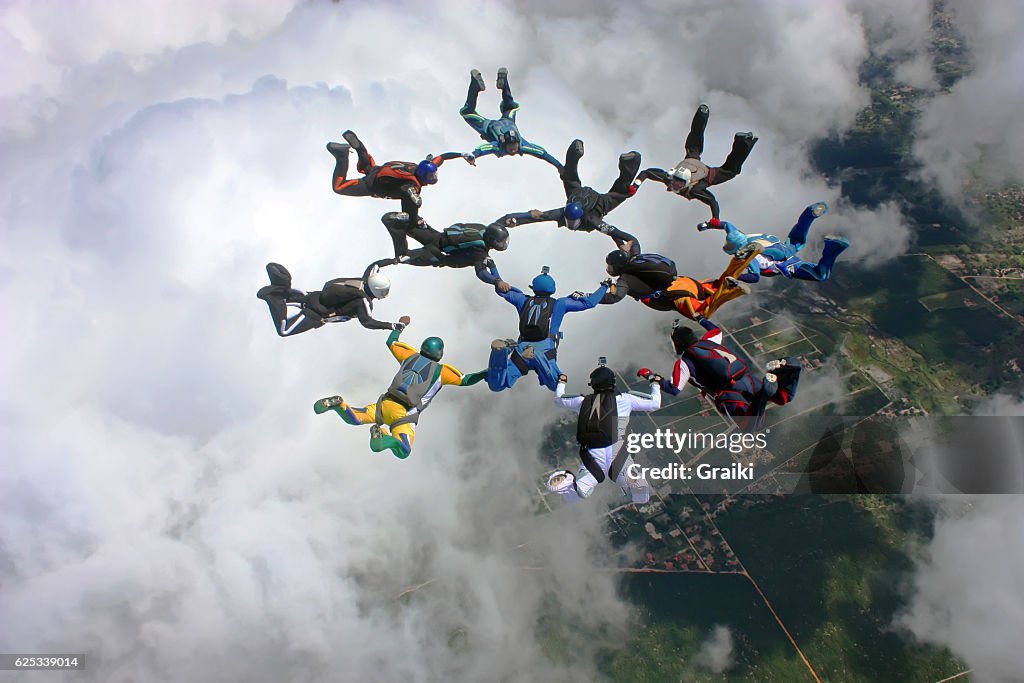 Skydivers make a formation above the clouds