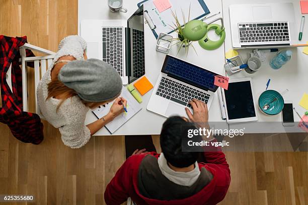 development team cooperating in their office. - writer desk stock pictures, royalty-free photos & images