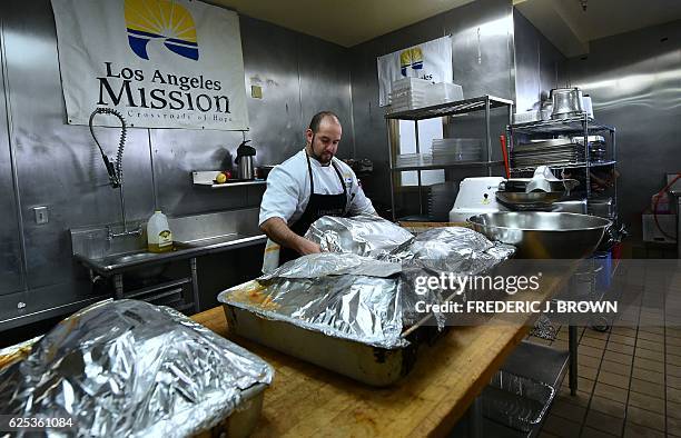 Daniel Rodriguez covers turkeys with foil before coking them in the kitchen at the Los Angeles Mission in Los Angeles, California on November 23...