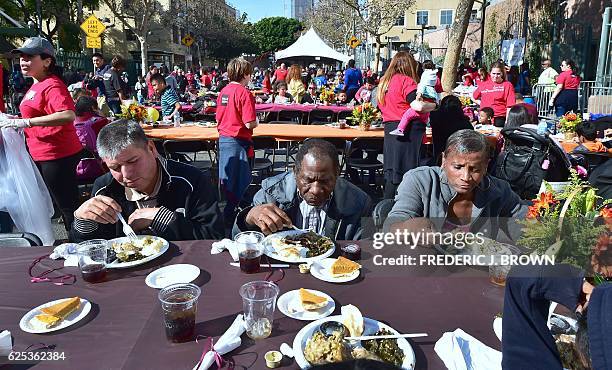 People in need and homeless eat at the Los Angeles Mission in Los Angeles, California on November 23 where up to 3,500 people are fed during the...
