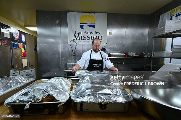 Daniel Rodriguez covers turkeys with foil before coking them in the kitchen at the Los Angeles Mission in Los Angeles, California on November 23...