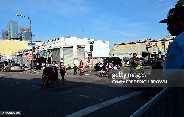 People walk to the Los Angeles Mission in Los Angeles, California on November 23 where up to 3,500 people are fed during the annual Thanksgiving meal...