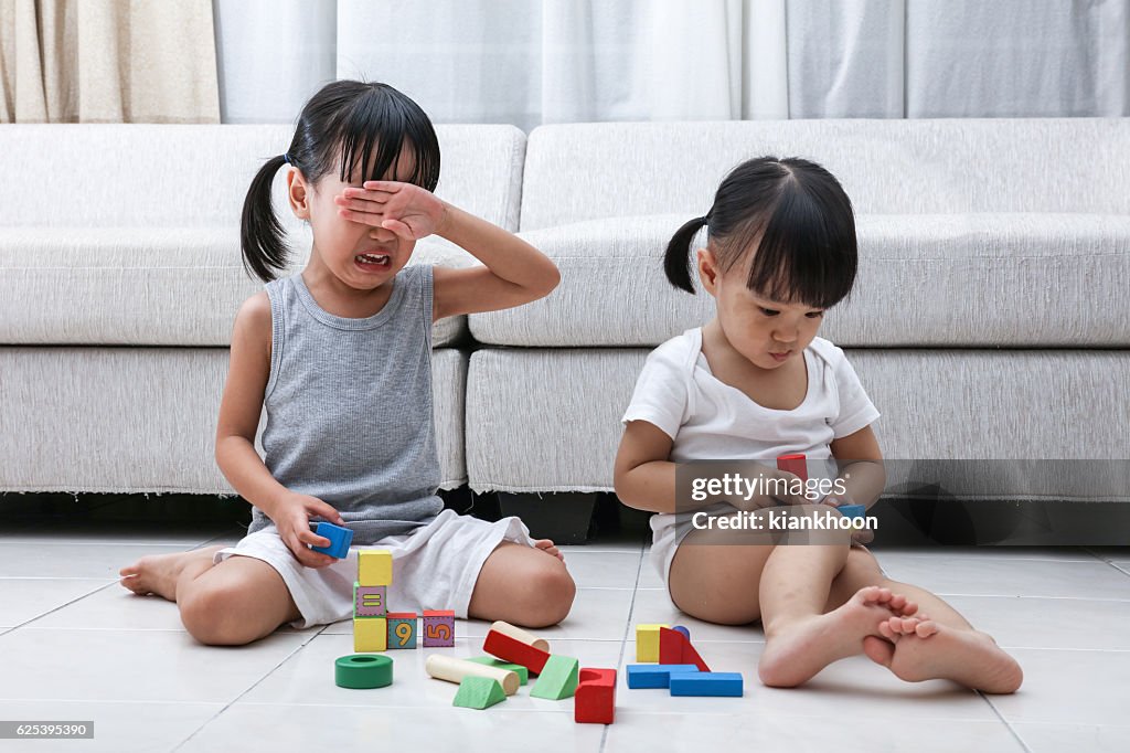Asian Chinese little sisters struggle for blocks