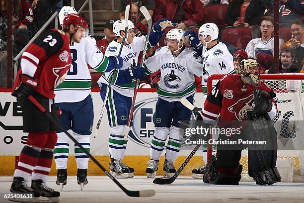 Sven Baertschi of the Vancouver Canucks is congratulated by Bo Horvat and Alexandre Burrows after scoring a goal against the Arizona Coyotes during...