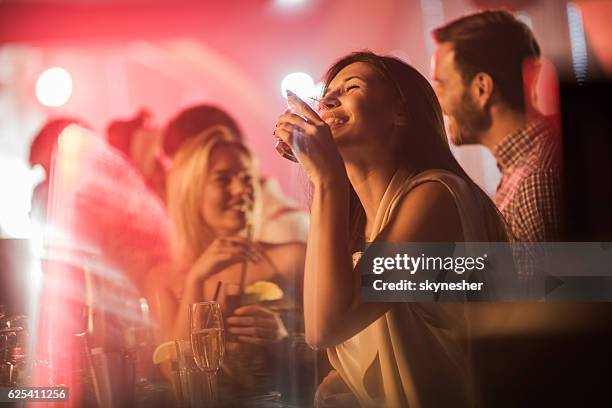 glückliche frau trinken an der bartheke in nachtclub. - bar people stock-fotos und bilder