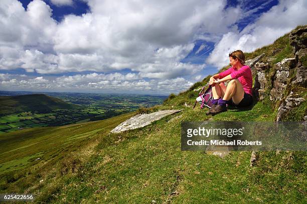 hiker admiring the views across the black mountains in the brecon beacons national park in wales - crickhowell stockfoto's en -beelden