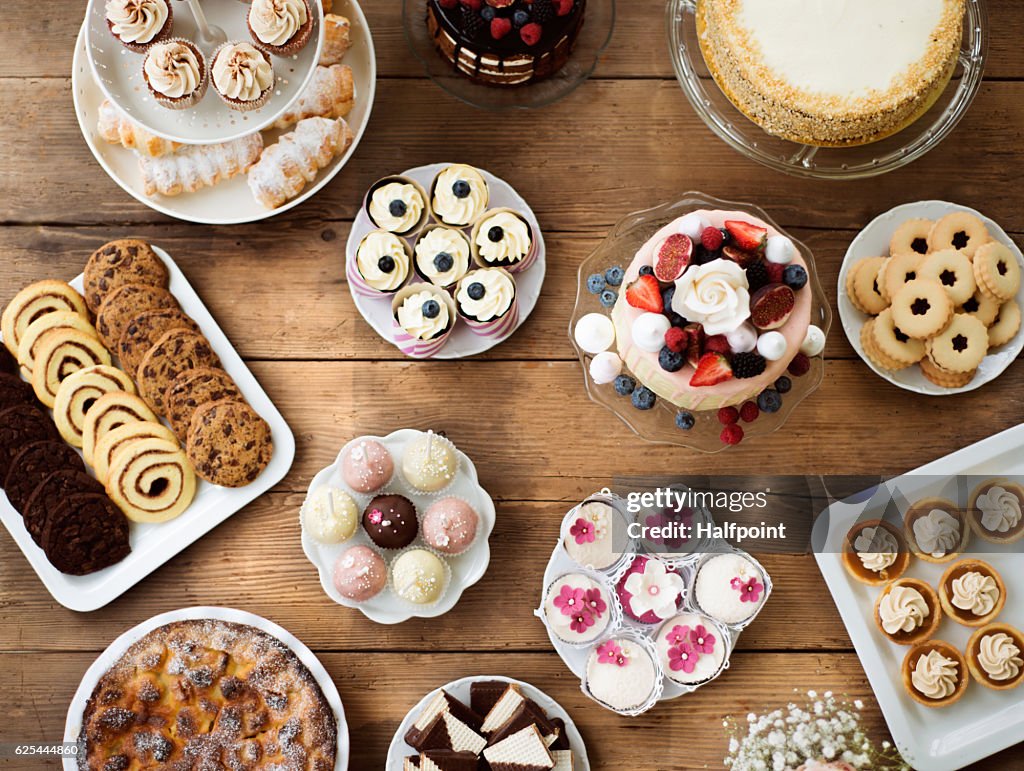 Table with cakes, cookies, cupcakes, tarts and cakepops.