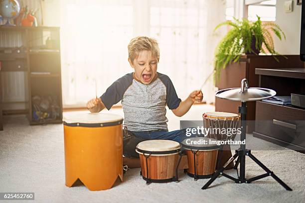 little boy making noise on makeshift drums - bongo drum stock pictures, royalty-free photos & images