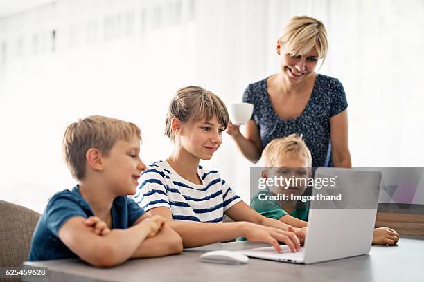 familie mit modernem ultrabook-computer - drei kinder stock-fotos und bilder