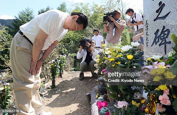 Japan - Japan Airlines Co. President Yoshiharu Ueki lowers his head at a cenotaph at the site of the 1985 JAL jumbo jet on Osutaka Ridge in the...