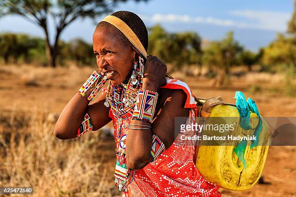 african maasai tribe mujer de transporte de agua, kenia, áfrica oriental - a beautiful masai woman fotografías e imágenes de stock