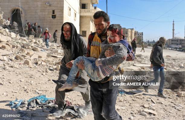 Syrian civil defence volunteer, known as the White Helmets, carries a boy rescued from the rubble following a reported barrel bomb attack on the Bab...