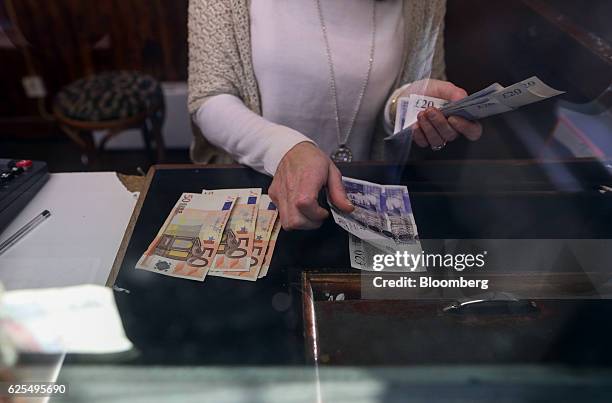 Cashier counts out British twenty pound sterling banknotes and fifty euro banknotes at an exchange bureau at the border between Northern Ireland and...