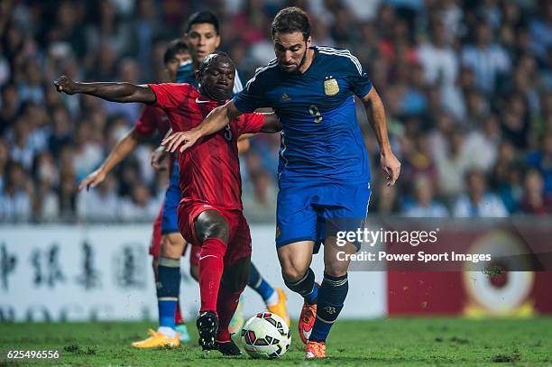 Gonzalo Higuain is followed by Fofo Wisdom Agbo of Hong Kong during the HKFA Centennial Celebration Match between Hong Kong and Argentina at the Hong...
