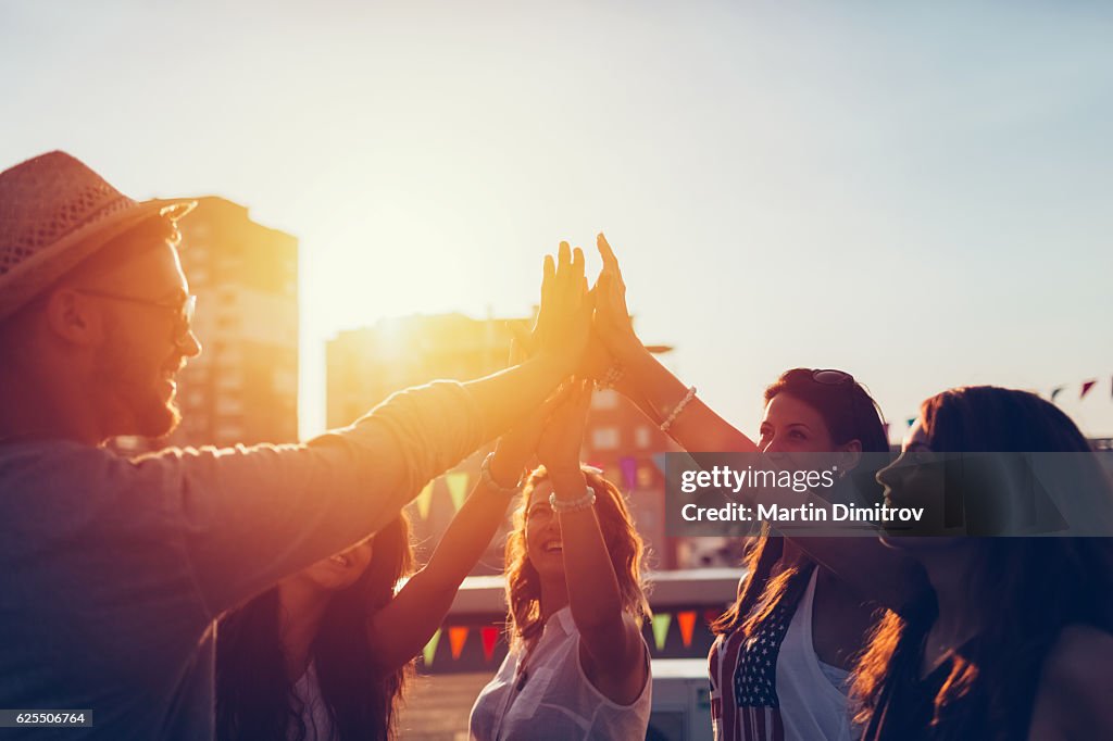 Gruppe von Freunden auf dem Dach tun high five