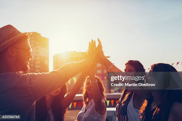 group of friends at the rooftop doing high five - hi five stockfoto's en -beelden