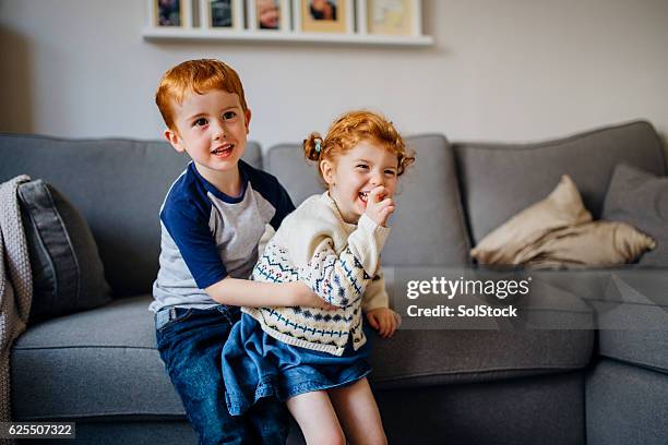 siblings playing at home - sister stockfoto's en -beelden