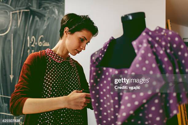 young fashion designer working in her workshop - pinning stock pictures, royalty-free photos & images