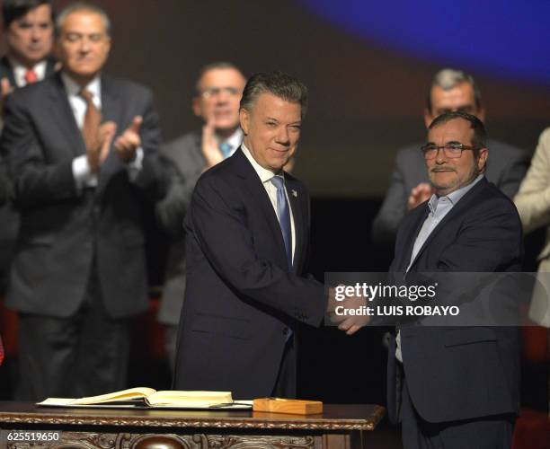 Colombian President Juan Manuel Santos and the head of the FARC guerrilla Timoleon Jimenez, aka Timochenko, shake hands during the second signing of...