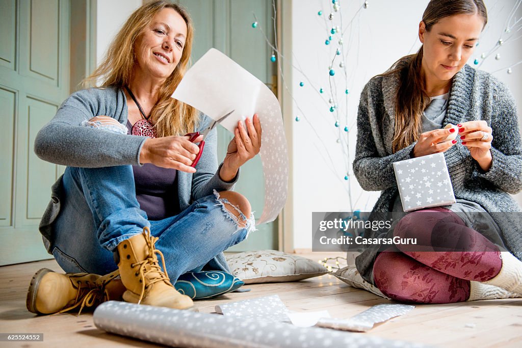 Mère et fille enveloppant des cadeaux de Noël