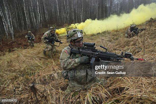 Members of the U.S. 173rd Airborne Brigade attack a trench position during the Iron Sword multinational military exercises on November 24, 2016 near...